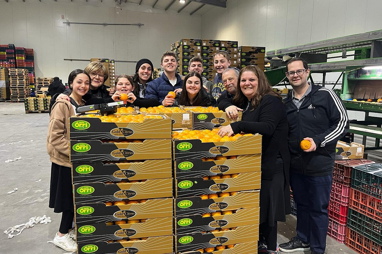 The Posner family from Woodmere, N.Y., and the Wiesel family from Edison, N.J., packing oranges in Pa'amei Tashaz, Israel. Photo courtesy of AFYBA.